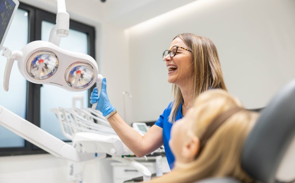 A,Dentist,Joyfully,Engages,With,A,Young,Patient,During,A