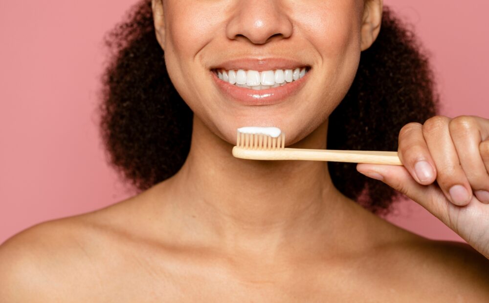 Wooden,Eco,Toothbrush,,Dental,Care,And,Sustainability,Against,Pink,Background.