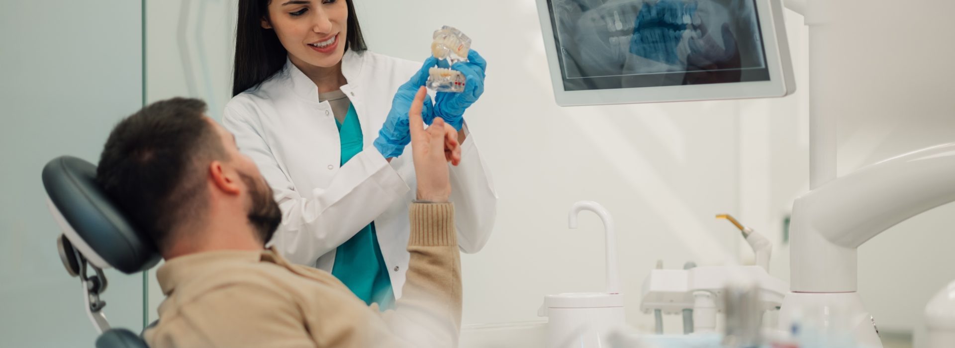 Female,Dentist,Is,Showing,A,Teeth,Model,To,A,Male